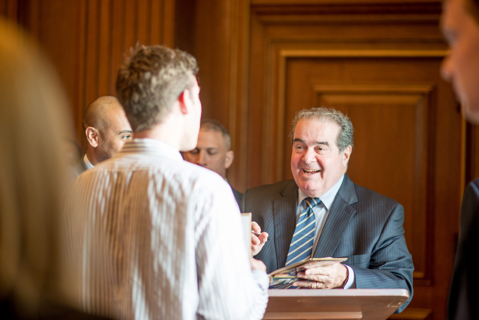 U.S. Supreme Court Justice Antonin Scalia signs a book for an LSI student following a briefing on Capitol Hill in May
