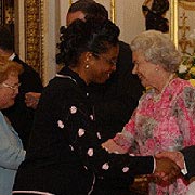 Inez K. Miles (E 71) shakes hands with Prince Philip after accepting an award from Queen Elizabeth II.