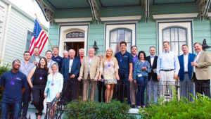 A group of people gather outside of a house for a photo at the 2018 Annual Conference.