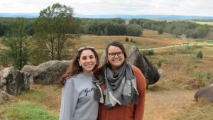 Two Public Policy Fellows stand side-by-side for a photo in front of a landscape during a tour of Gettysburg, Pennsylvania, at the public policy retreat.