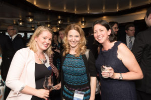 Three friends stand together at a TFAS event.